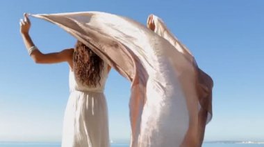 woman holding and raising a fabric floating in the wind
