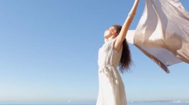 woman holding and raising a fabric floating in the wind