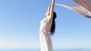 woman holding and raising a fabric floating in the wind