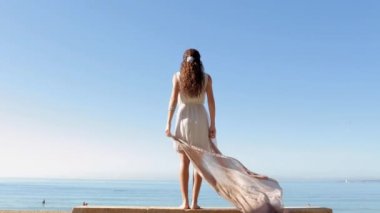 woman holding and raising a fabric floating in the wind