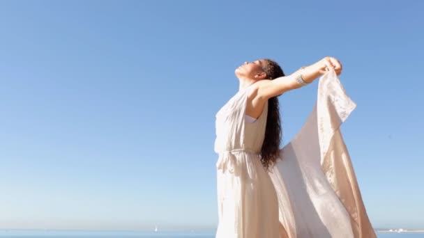 Woman holding and raising a fabric floating in the wind — Stock Video