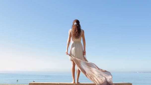 Woman holding and raising a fabric floating in the wind — 비디오