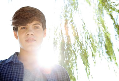 teenager boy being thoughtful and looking at the camera
