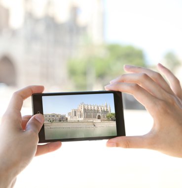 woman taking photos of a monument cathedral