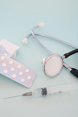 doctor stethoscope with medicine pills and a serynge