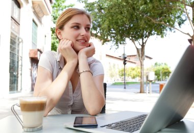 business woman drinking a beverage with a laptop