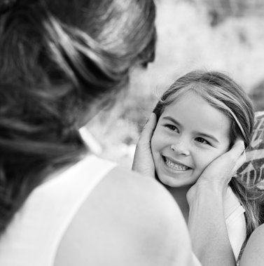 mother holding her daughter face in her hands