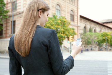 businesswoman using smartphone in a city