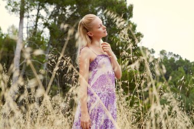 blond woman relaxing in a field