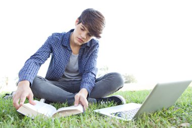 boy in a park readding a book