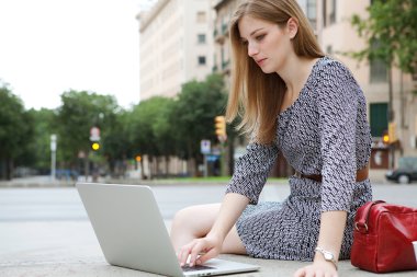 business woman using a laptop computer outdoors