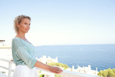 woman relaxing in resort hotel balcony