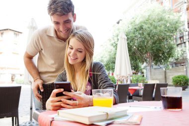 couple using a smartphone at cafe