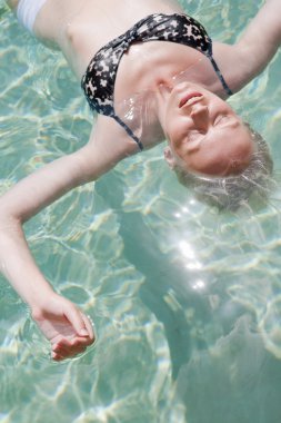 sarışın kadın rahatlatıcı bir yüzme havuzunda