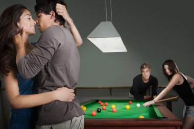 couples playing pool together in a bar