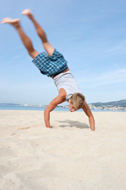 boy doing cartwheels with his legs up in the air