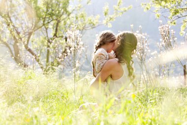 Mother and daughter hugging in a spring field