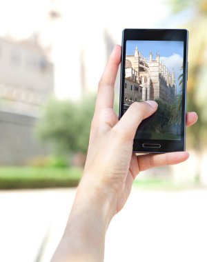 woman taking pictures of a characterful architecture cathedral