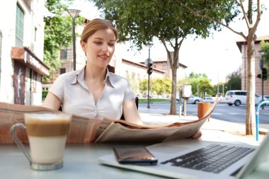 business woman reading a financial newspaper at cafe