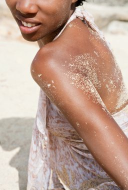 black woman relaxing on a sandy beach