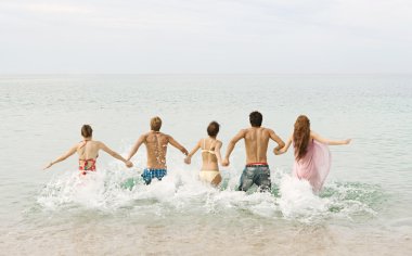 friends running into the sea water together