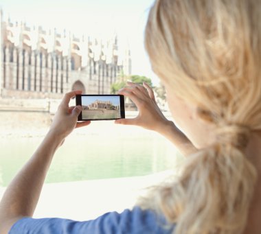 woman taking photos of a monument cathedral