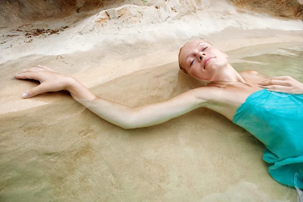Mujer flotante y relajante de una piscina natural — Foto de Stock