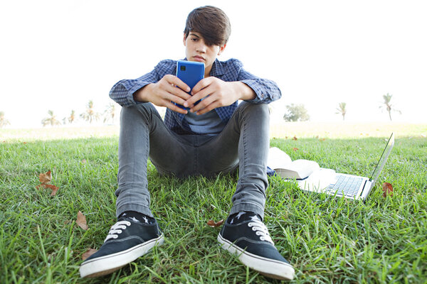 boy using his smartphone in park