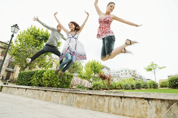 Friends jumping up in the air together — Stockfoto