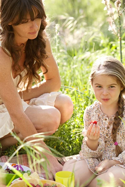 Mère et fille pique-niquer dans un jardin — Photo