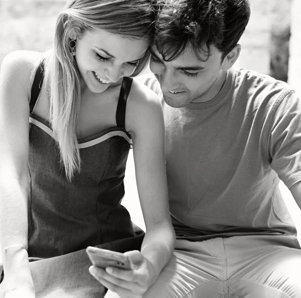 Tourist couple using a smartphone — Stock fotografie