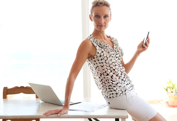 Woman using a smartphone in office — Zdjęcie stockowe