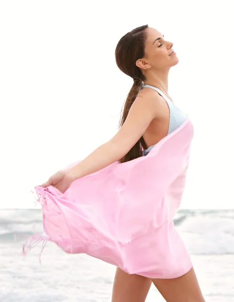 Жінка на пляжі з рожевою тканиною сарон — стокове фото