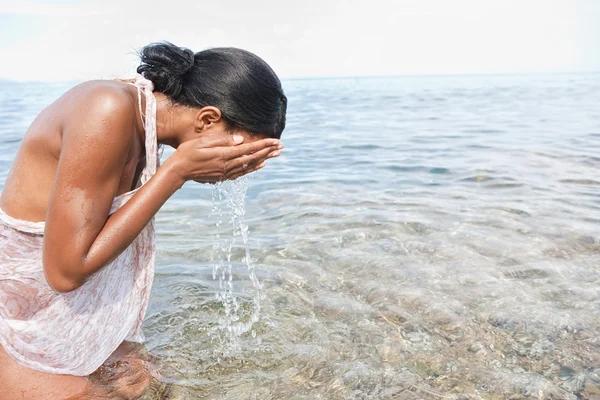 Black woman splashing sea water on her face — Φωτογραφία Αρχείου