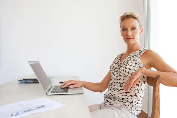 Kvinna med hjälp av en bärbar dator i huvudkontoret — Stockfoto