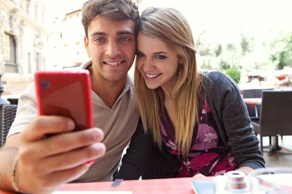 Casal usando uma câmera de smartphone para tirar uma foto selfie — Fotografia de Stock