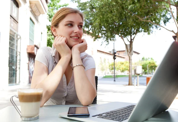 Business woman drinking a beverage with a laptop — Zdjęcie stockowe