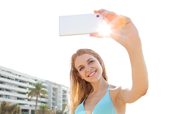 Woman taking selfies pictures near resort hotel — ストック写真