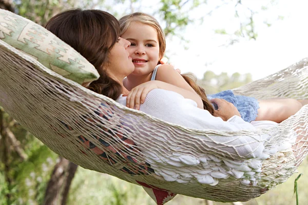 Daughter and her mother laying together in a hammock — ストック写真