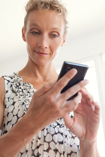 Mujer de negocios usando un dispositivo de teléfono inteligente — Foto de Stock