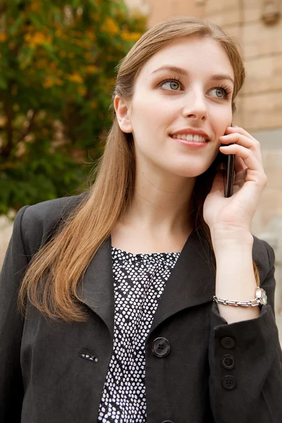 Mujer de negocios sonriendo y teniendo una conversación de llamada telefónica —  Fotos de Stock