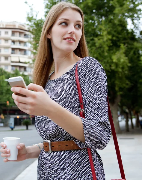 Mujer de negocios sosteniendo y usando un teléfono inteligente — Foto de Stock