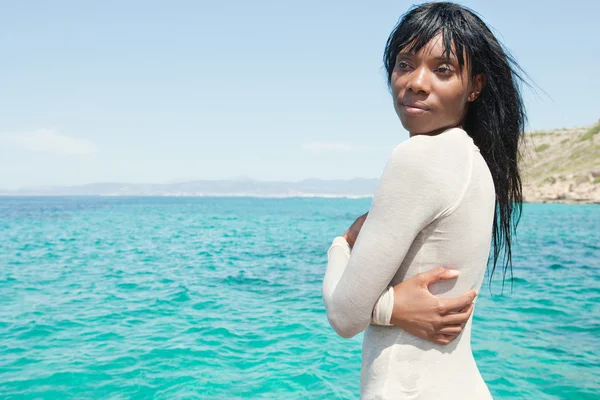 Mulher negra de pé em uma praia perto do mar — Fotografia de Stock