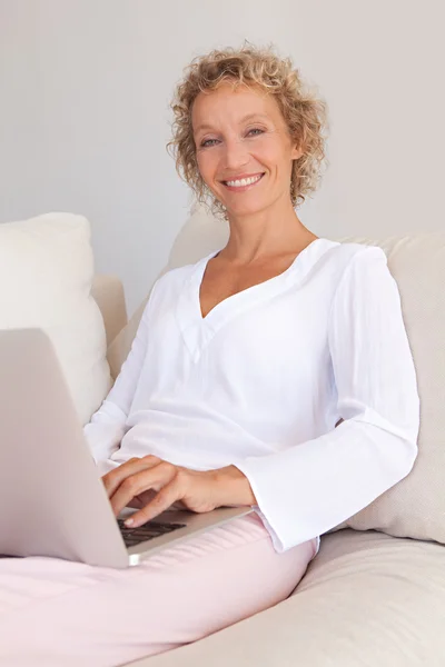 Mulher usando um computador portátil e trabalhando — Fotografia de Stock