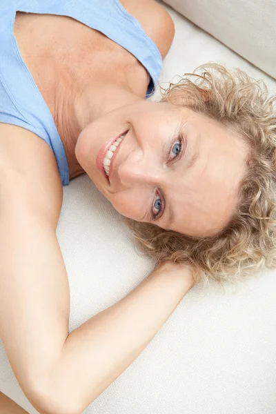 Woman relaxing on a white sofa at home — Stock Photo, Image