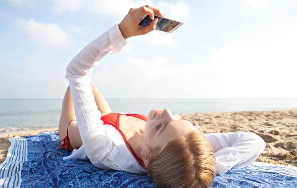 Женщина с помощью смартфона на пляже — стоковое фото