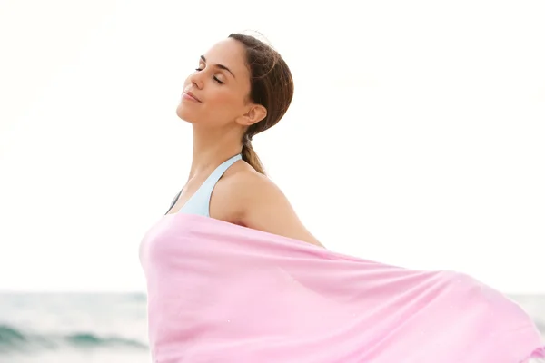 Femme sur une plage avec un sarong en tissu rose — Photo