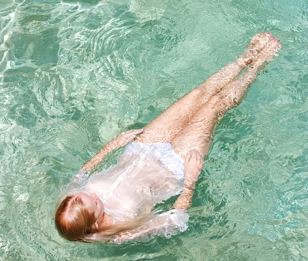 Mujer joven nadando en una piscina — Foto de Stock