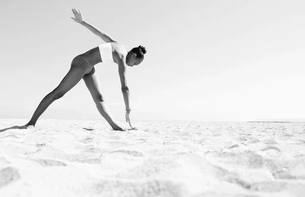 Young woman exercising on a bea — Stok fotoğraf