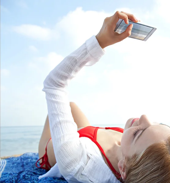 Vrouw met smartphone op het strand — Stockfoto